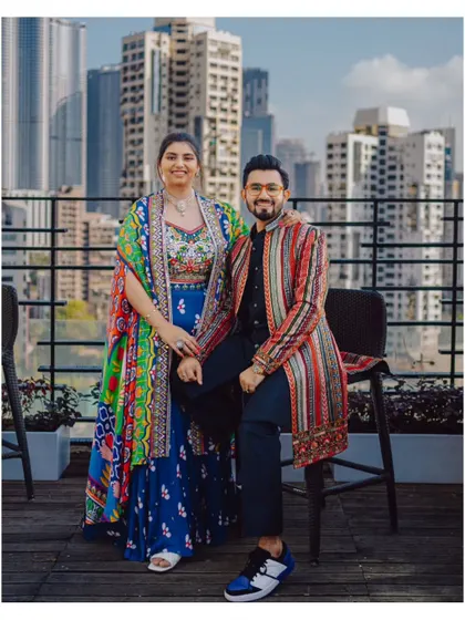 A stylish portrait of the couple on a rooftop with the city skyline behind them, showcasing a modern urban celebration.