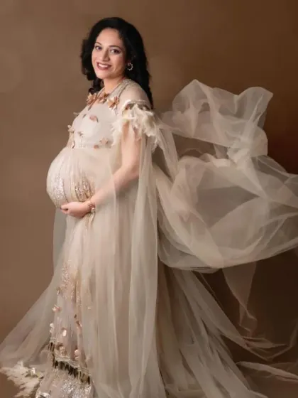 The sheer cape of this beige gown creates a beautiful, flowing effect, adding a touch of ethereal grace to a fitted silhouette.