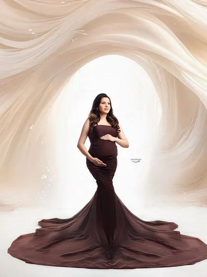 A dramatic and powerful portrait featuring a fitted brown gown. The swirling fabric effect in the background creates a sense of movement and artistry, framing the client beautifully.