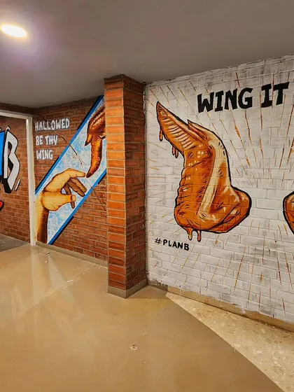 A collection of our wing-themed murals for Plan B, including a graffiti logo, a parody of Michelangelo's "The Creation of Adam," and a "Wing It On!" piece.
