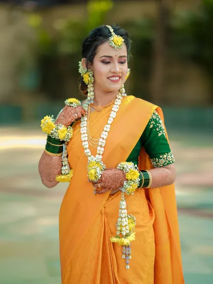 A radiant bride during her Haldi ceremony, adorned with traditional floral jewelry. Capturing bridal portraits is one of my favorite parts of the day.