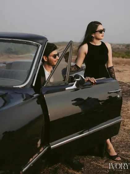 A high-fashion shot from the Goa vintage car series. The couple exudes confidence and style as they pose with the open door of the classic Chevrolet, looking like stars in their own film.