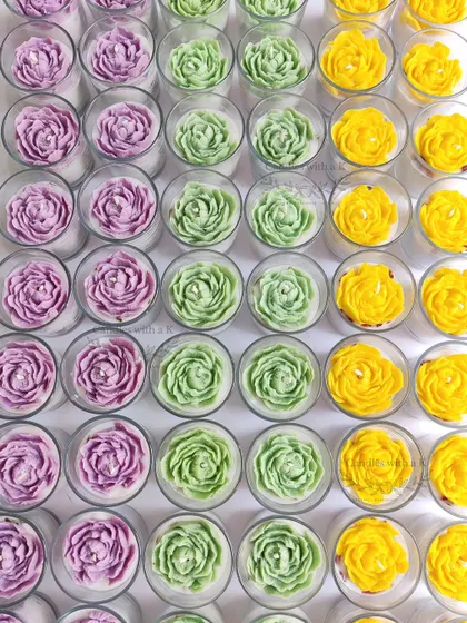 A full-frame shot of the peony candles, showing the beautiful texture and vibrant colors of the handmade wax flowers.