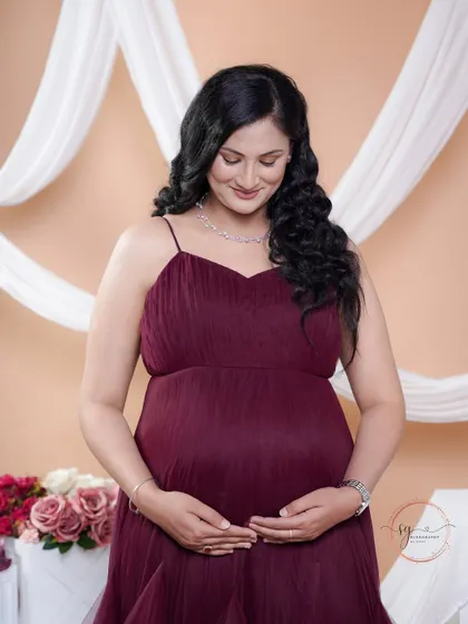 A quiet moment of connection. The mom-to-be looks down at her bump, her expression full of love and anticipation.