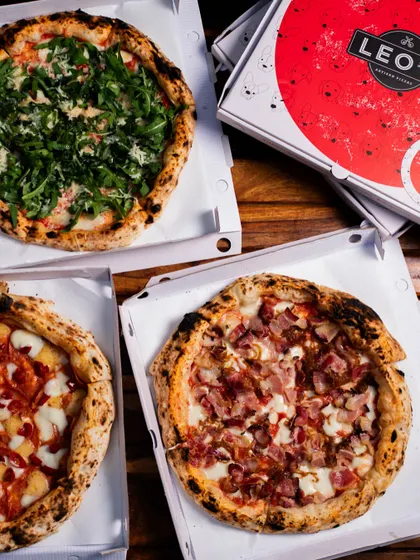 A trio of our pizzas boxed up and ready for delivery, including a delicious bacon pizza.
