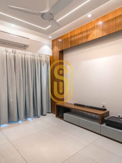 A minimalist TV unit designed for a clean and uncluttered look. The wooden paneling on the wall adds warmth, while the low-profile console provides essential storage without overwhelming the space.