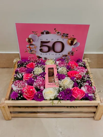 A full view of the 50th birthday floral arrangement. The wooden crate and personalized "Happy 50th Birthday" card make this a standout gift.