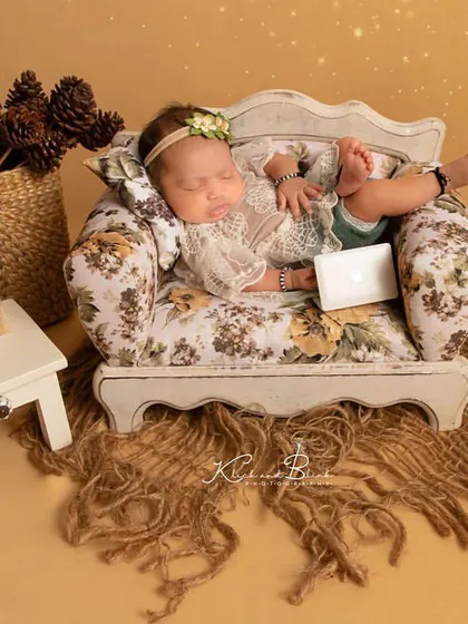 Such a poser. This little girl rests comfortably on a miniature sofa, surrounded by rustic decor, looking completely at ease and oh-so-cute.