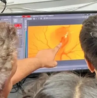 Children look at a magnified image on a screen in a research lab, getting a glimpse into the high-tech tools scientists use to study the natural world.