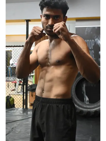 A fighter in a classic boxing stance, ready for action. The physique is a result of dedicated training and a disciplined lifestyle.