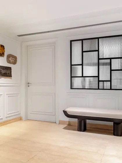 A minimalist bench from our Koko collection provides a serene seating nook in the passage of the Magnolia project. Its simple, sculptural form is a quiet counterpoint to the bold textural artworks on the wall, creating a harmonious balance.