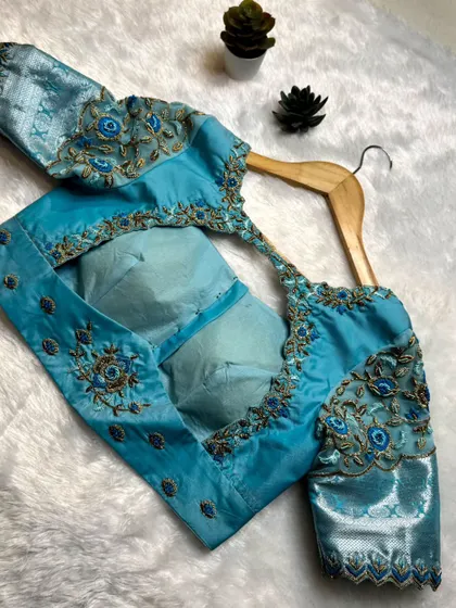 This stunning sky blue blouse with detailed embroidery is available for rent. Perfect for upgrading any saree.