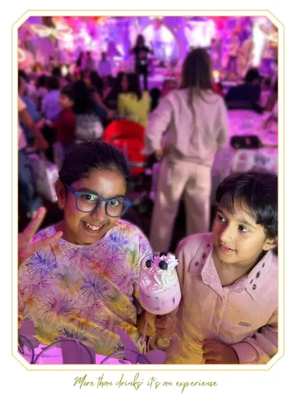 A young guest enjoying a fun, whipped-cream-topped mocktail at a birthday party. We create special, non-alcoholic options for our youngest VIPs.