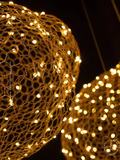 We call this piece the 'Clouds of Abundance'. Formed from a delicate honeycomb mesh of gold wire embedded with tiny LED lights, these fixtures float like luminous clouds, casting a warm and magical glow.