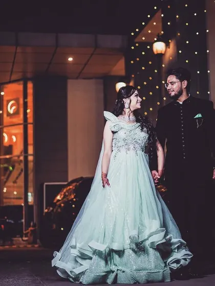 A grand, fairytale-like shot of a couple outside a modern, well-lit venue. This style of pre-wedding photography is perfect for capturing a glamorous, elegant look.