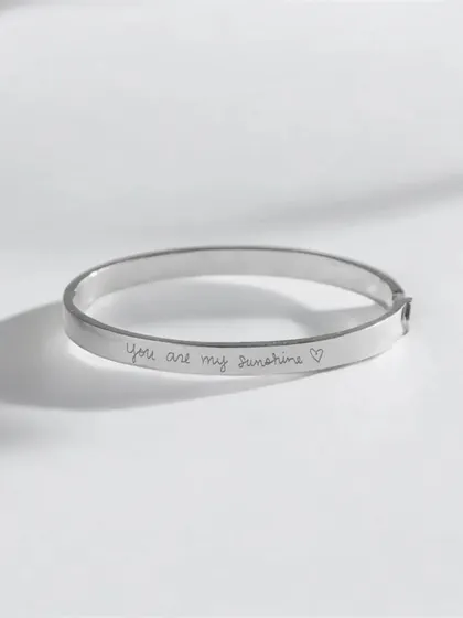 A clean product shot of a silver cuff bracelet engraved with the handwritten-style quote "You are my sunshine ♡". This is a perfect example of how I can engrave personal messages and affirmations.
