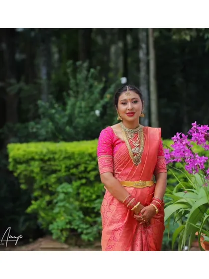 A full-length shot of the bride in a beautiful outdoor setting. Her makeup is kept fresh and radiant, perfect for a daytime wedding ceremony.