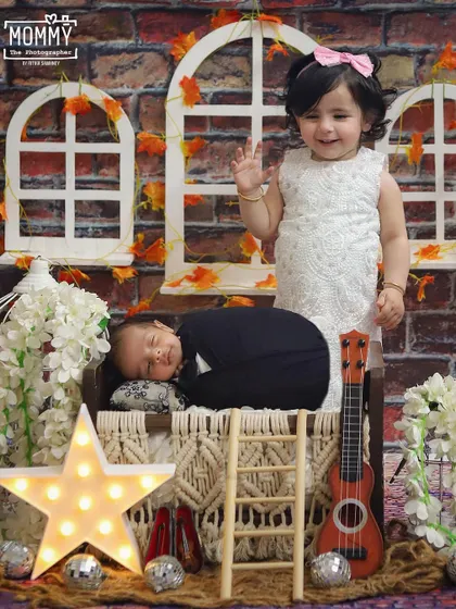 "Chand Taaro Se Kaho..." A magical newborn and sibling setup with stars, a little guitar, and a rustic backdrop. The big sister waving is just the cutest touch!