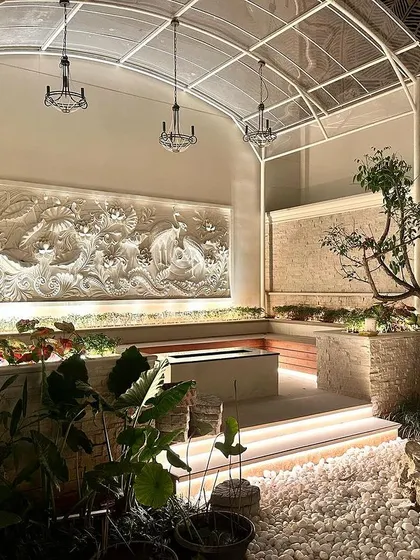 A full view of the semi-enclosed courtyard project at Epsilon layout. The combination of the intricate wall mural, stone planters, wooden seating, and a central water feature creates a truly unique and tranquil space.