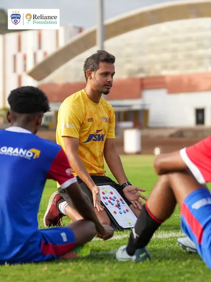 A coach uses a tactics board to explain formations and strategy to the players. We focus on developing tactical understanding alongside technical skill.