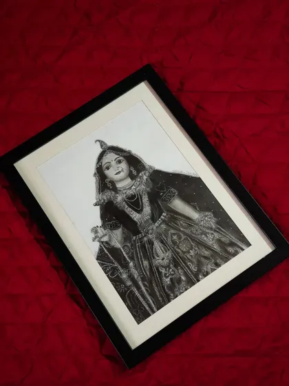 The framed Radha Rani portrait against a rich red background, highlighting the contrast and the emotional depth of the piece.
