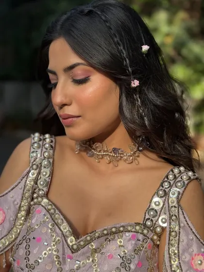 A close-up of the eye makeup and the delicate braids. This combination of soft glam and bohemian details is perfect for a Mehendi carnival.