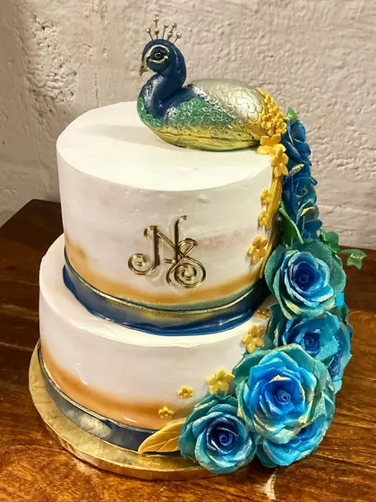 A still shot of the majestic peacock cake, showcasing the intricate details of the feathers and the monogram.