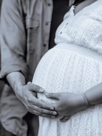 A timeless black and white close-up of a couple's hands on the baby bump. This artistic shot emphasizes the shape and the connection without any distractions.