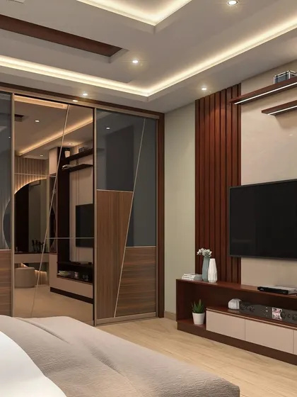 This bedroom combines entertainment and storage seamlessly. A sleek TV unit is flanked by a sliding wardrobe with mirrored and wood-finish panels, maximizing functionality in a stylish way.