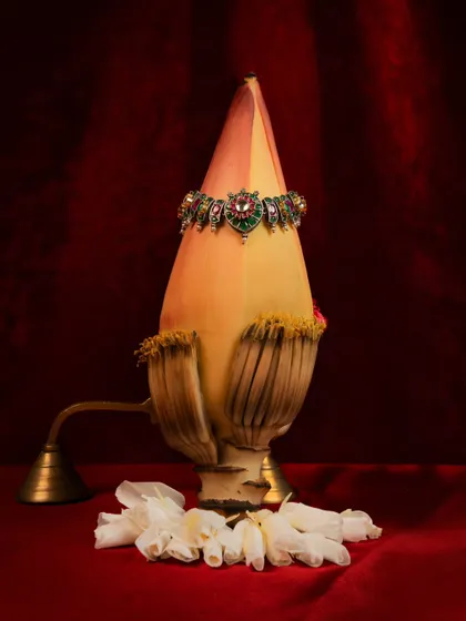 A still-life product shot of a beautiful piece of jewelry, creatively displayed on a banana flower. This unique, organic presentation is artistic and makes the product stand out.