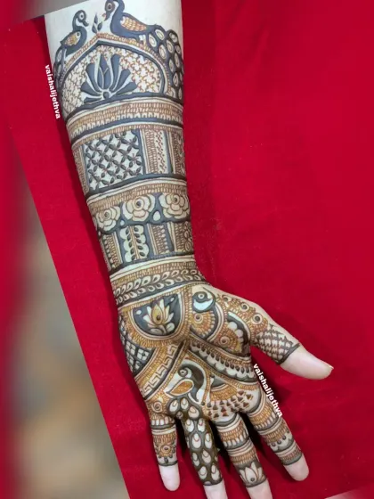 A full-arm design with peacocks and a lotus on top. The combination of bold figures and intricate fillers creates a stunning bridal-style look.