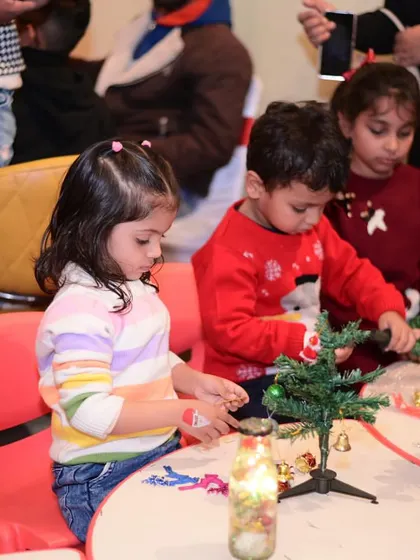 Little elves at work! Children participated in a Christmas craft session, decorating their own mini Christmas trees to take home.