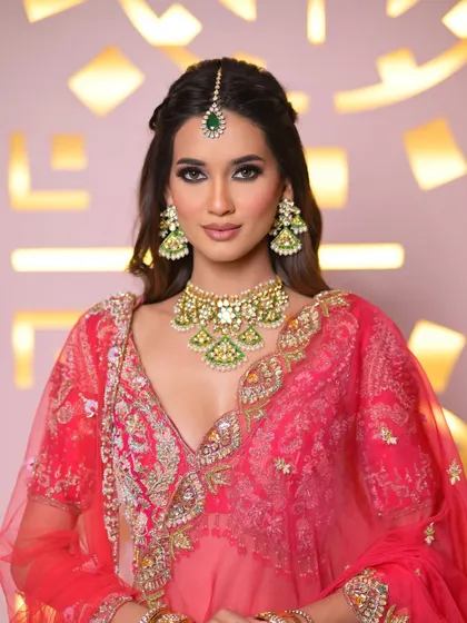 The full view of the pink lehenga, showing how the makeup and hair work together to create a complete, harmonious bridal look.
