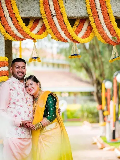 A playful and romantic portrait of the couple under a vibrant floral archway. We use the decor to frame your love story beautifully.