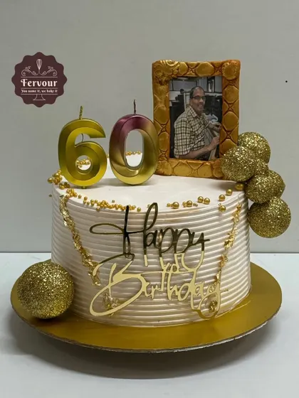 A 60th birthday cake with a personal touch. This chocolate truffle cake features an edible photo in a golden frame, along with glittery gold balls and a custom topper.