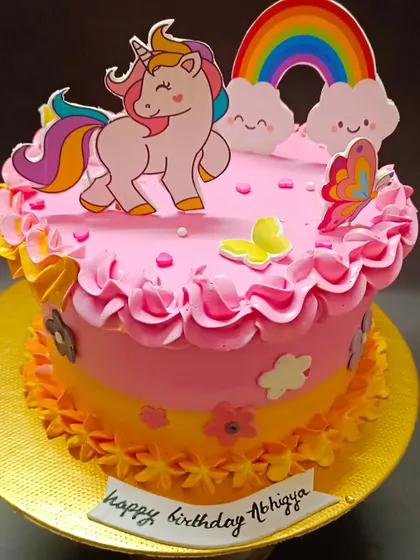 A sweet and simple unicorn cake with a rainbow and butterfly accents, perfect for a happy birthday.