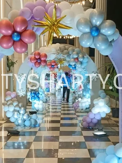 Multiple layered arches in purple and blue create a stunning tunnel effect for this Frozen party entrance, decorated with balloon snowflakes.