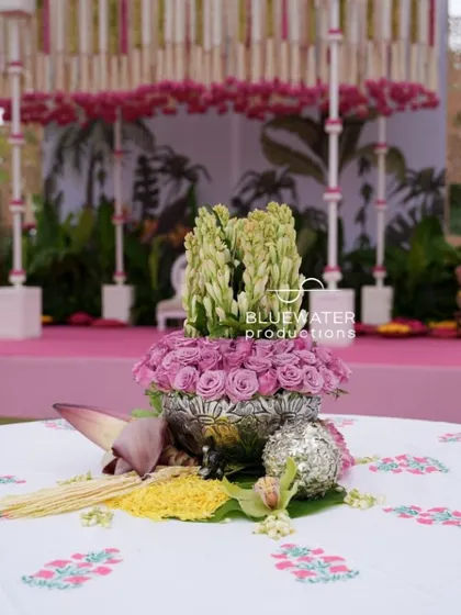 A beautiful centerpiece for a traditional ceremony, featuring roses and tuberoses in an ornate silver bowl.