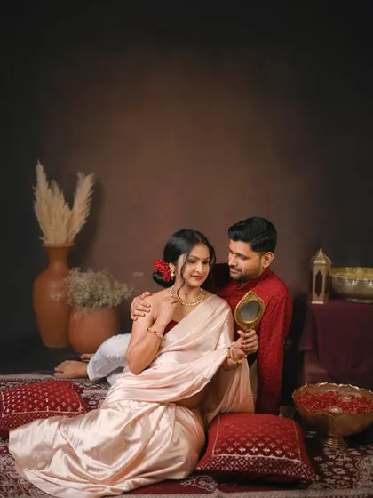 A playful and romantic moment where the husband holds a mirror for his wife. This is a sweet, storytelling shot from a traditional couple's maternity session.