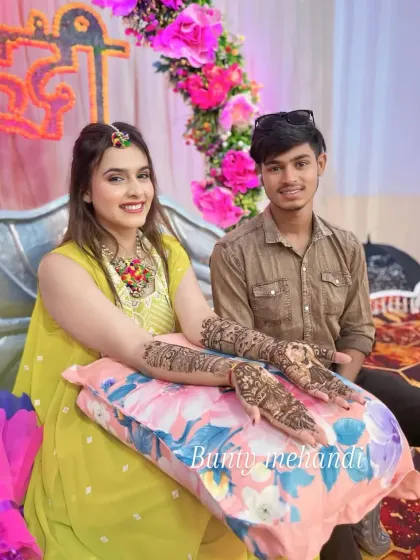 One of my artists with a happy client, showcasing her beautiful and intricate full-arm mehandi.