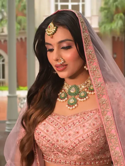Draped in her dupatta, this modern bride looks ethereal. The soft makeup and gentle waves in her hair create a romantic and timeless feel, perfect for her special day.