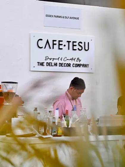 A candid shot of the barista at the Cafe Tesu counter, showcasing the functional and aesthetic design of the service area we built.
