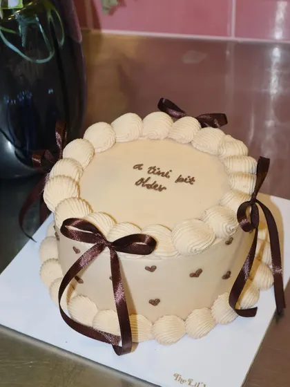 A classic and elegant mocha cake decorated with delicate brown ribbons and piped swirls. Inside, it's a rich and indulgent Belgian chocolate cake, making it a truly decadent treat for any occasion.