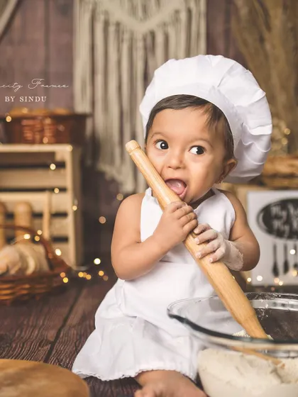 Is the rolling pin for baking or for tasting? This funny moment from the chef-themed shoot perfectly captures the curiosity of a baby.