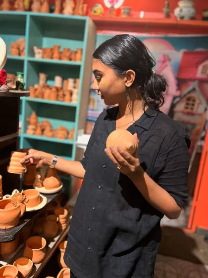 Browsing through our collection of terracotta pottery, a guest selects the perfect pieces to paint.