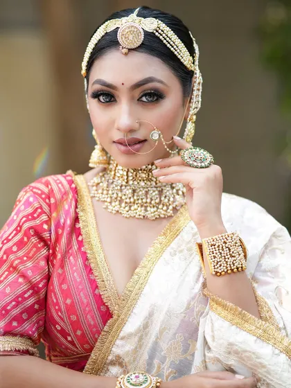 A stunning close-up of this unique bridal look. The sharp, winged eyeliner and traditional mathapatti create a powerful and captivating style.