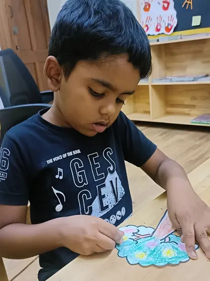 A student works on his seasons craft, fully engaged in the activity.
