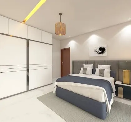 A clean and modern bedroom design with a large sliding wardrobe in white. The simple color palette of white, grey, and blue creates a calm and uncluttered environment perfect for relaxation.