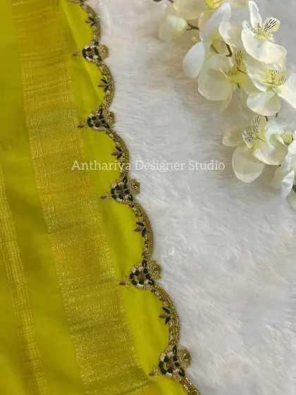 A close-up of the scalloped and embroidered border of the matching saree.