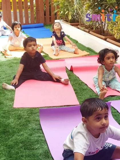 Children practice a seated stretch on their yoga mats in our garden. Yoga is a wonderful way to develop both physical flexibility and mental focus.